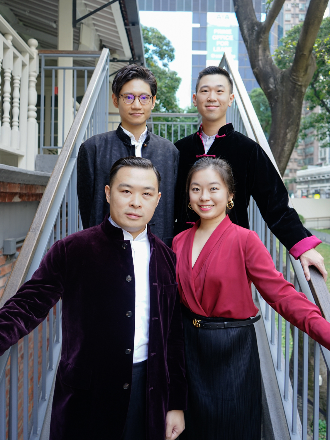 A group of people posing for a photo on a staircaseDescription automatically generated with medium confidence